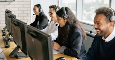 A diverse group of call center employees working together at desks in a modern office.